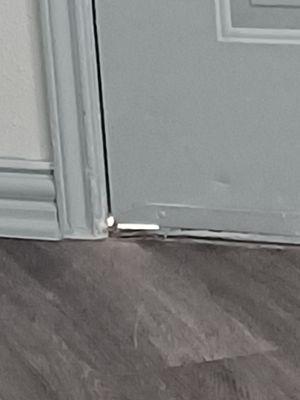 Gap at the bottom of the front door where spiders, lizards & rollie pollies crawl in.