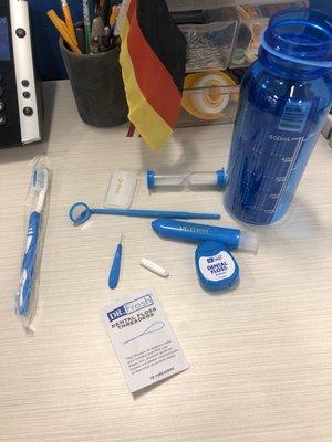 The goodie bag--two toothbrushes, a timer, floss, floss threader, mirror, braces wax, all inside a water bottle.