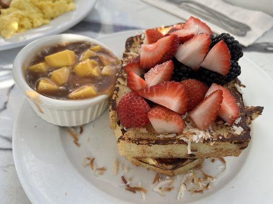 Coconut French toast with caramelized mango, caramel sauce, and berries.