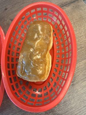 Maple bar on a red plastic basket with no wax paper.