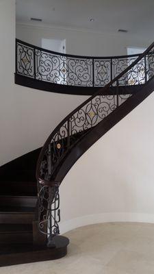 Hand forged iron railing with bronze details and wood cap