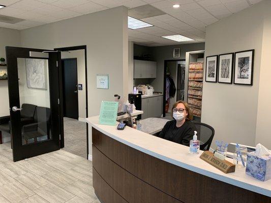 Smiling receptionist behind her mask.