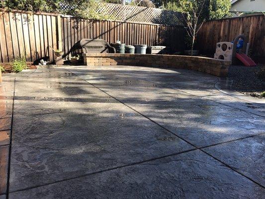 Stamped Colored Concrete patio and roman stone seat wall