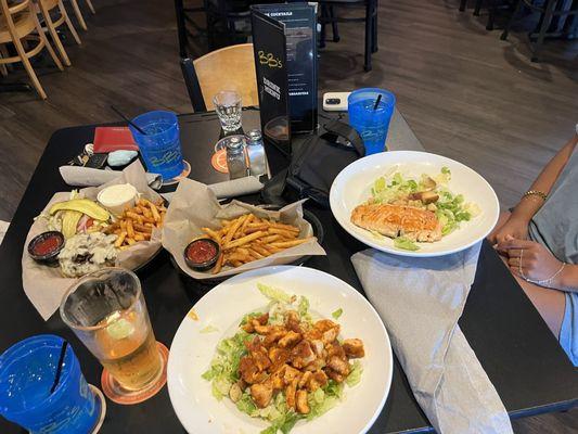 Mushroom Swiss burger, buffalo chicken Caesar salad, salmon Caesar salad and fries.