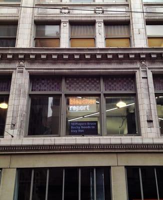 The Bleacher Report neon sign seen from below on Kearny Street in San Francisco.