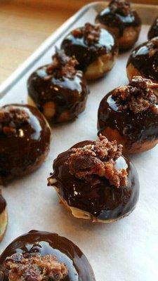 Peanut butter bacon donut hole with a dark chocolate ganache.