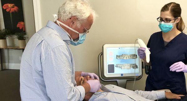 Dr. Baker performs an Invisalign smile assessment using an iTero digital scanner.