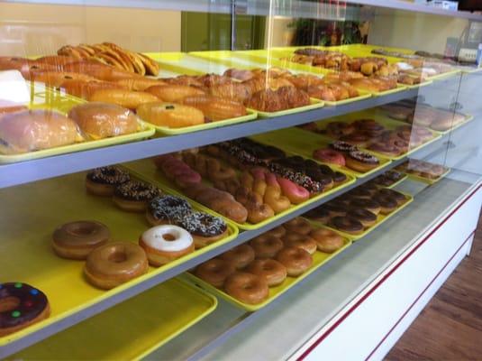 Display case full of donuts and kola he's.