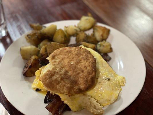 Egg & cheese biscuit with bacon and a side of potatoes