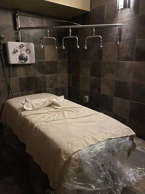 Massage table w/ Vichy shower. After Vichy, plastic layer is stripped and new sheets are underneath for a quick transition to warm and dry!