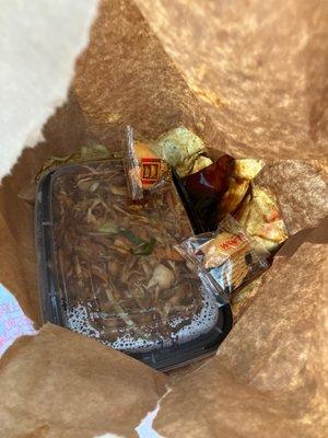 The completely soaked and leaking bag the food was served in.