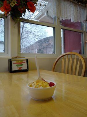 Butterscotch sundae, chair, and window. There's a storm rolling in over the mountains.