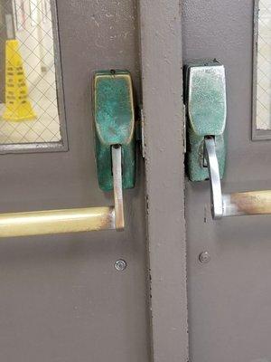 Green rust on the door handles leading to the main area of the Y from the pool