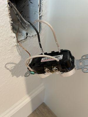 Electrician thought it was ok to jump a neutral to a ground. This is called a  "bootleg ground". To avoid rerunning wires