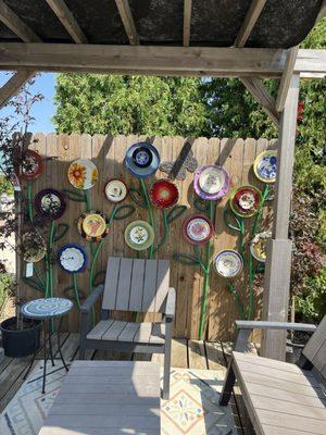 Clever up-cycle flower wall made from garden hose and plates