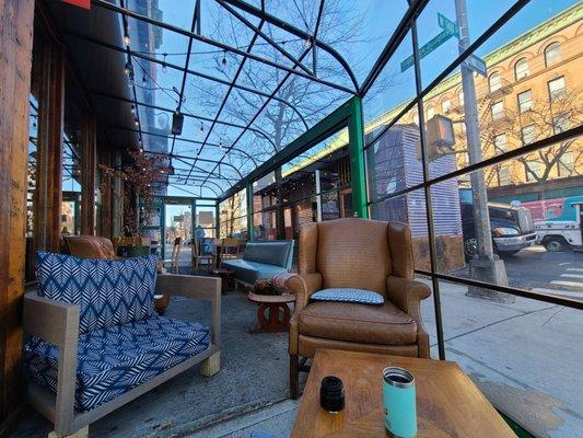 Glass covered outdoor sun room. Lovely on a brisk Saturday morning.