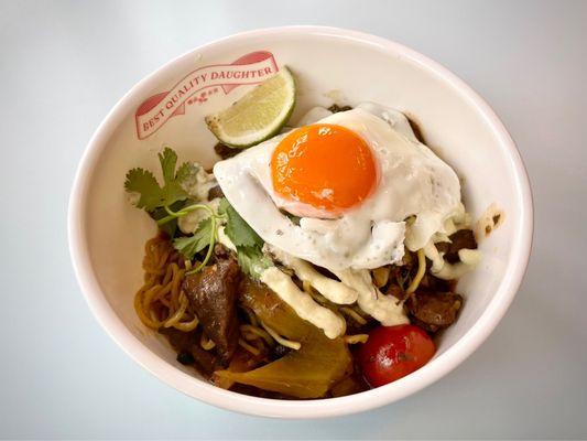 Curry guisada Dan Dan with Peeler Farms Wagyu beef, heirloom tomatoes, fermented black beans, salsa verde cremosa, and a fried egg