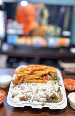 Flavorful lamb over rice with fries and veggies. Extra sauce on the side. Their hot sauce is better than what I am used to.