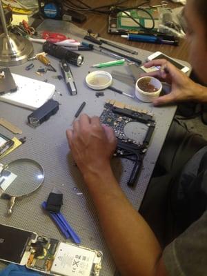 Macbook pro computer repair. Broken computer component soldering and fixing.