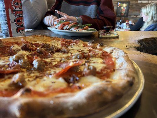 Iggy Pizza w/ caprese salad in background