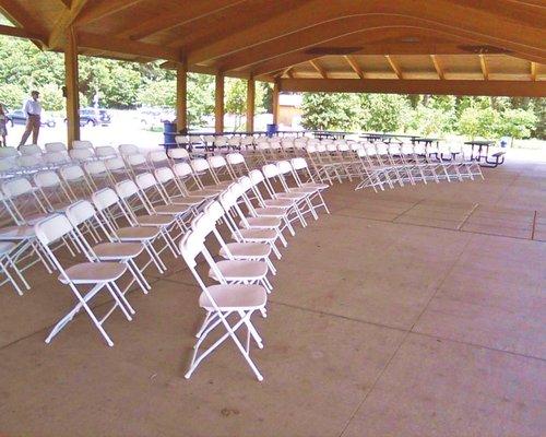 Cliff cave park pavillion. White plastic chairs. Set up in curved rows.