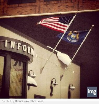 The flags of Michigan and the US blowing in a winter wind.