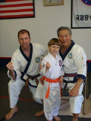 Master Glenn, and Grand Master C.S. Kim promoting a young student.