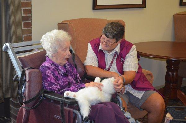 Volunteer Beth Carson shows Tinkerbell, a robotic cat, to a nursing home patient.