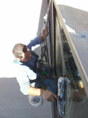 Severiano in the process of cleaning windows