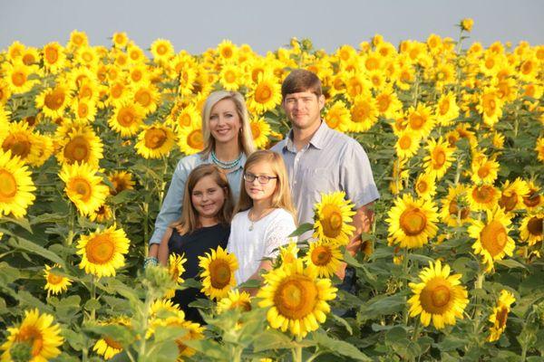 Clay and Valerie Oliver with daughters Maggie & Mollie in their sunflower field.