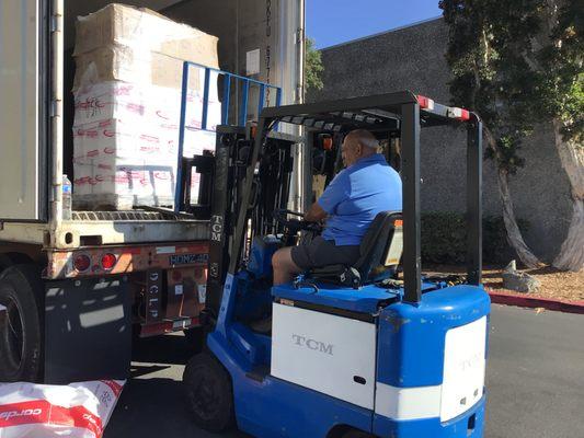 Forklift removing pallet of wine off an 18 wheeler