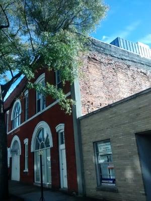 Exposed brick arches, now filled in with brick from when a taller building was next to it.. Would make awesome roof deck.. :)