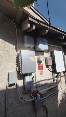 System solar components, the old breaker box, and J-Box mounted over old breaker box and in front of wall opening done to access wiring.