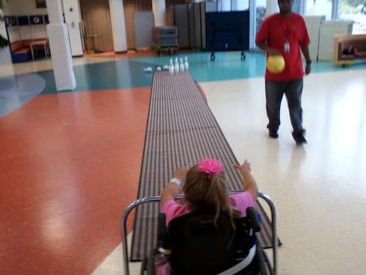 Kenzie bowling with a volunteer.