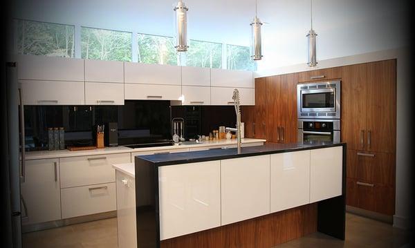 Modern European-inspired two-tone kitchen, wrap around waterfall countertops, glass backsplash..