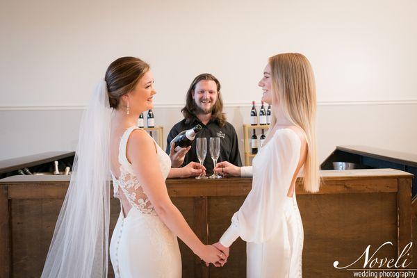 A happy couple smiling in front of Liquid Catering's mobile bar