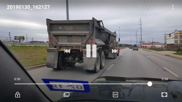 Rocks pouring out of improperly secured gate of truck on it's way to Custom-crete. These rocks hit my SUV and cracked the windshield.