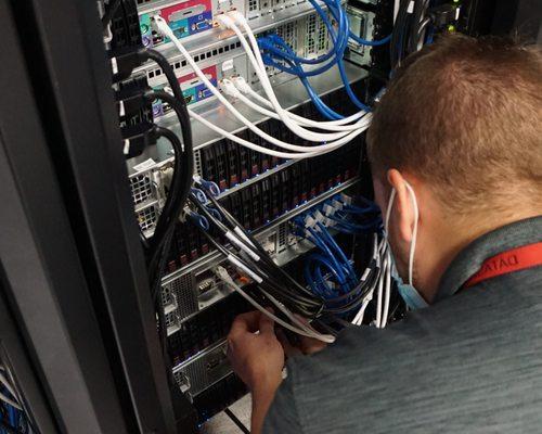 Chad inspects the cabling for a server racked in one of our data center cabinets.