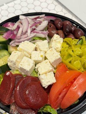 Fresh Greek Salad on a bed of romaine lettuce.