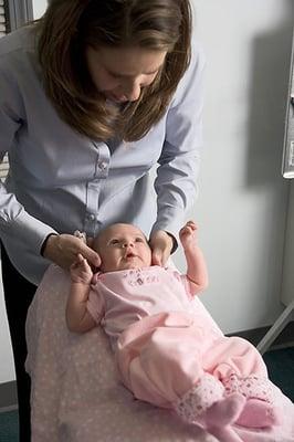 Dr Arlene checking an infant with gentle and safe chiropractic care.