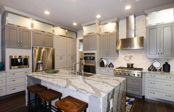 This large Quartz Kitchen Island has a dazzling waterfall edge detail.  The colors compliment the cabinetry colors.