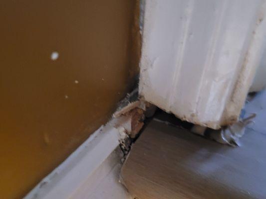 Damage to trim at top of stairs and poor caulking.