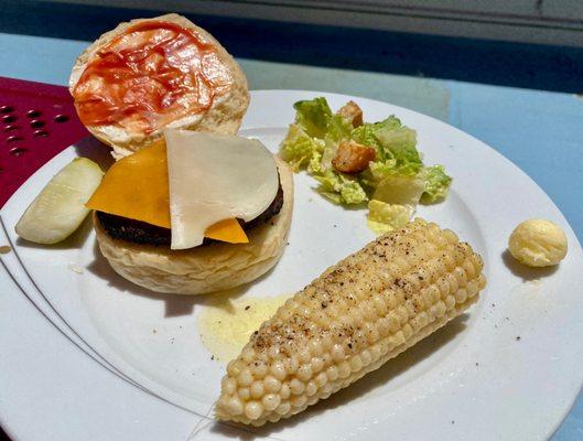 Cheeseburger, Caesar salad, and sweet corn with butter.