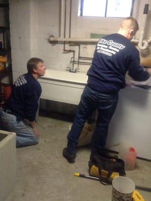 Carl and his assistant changing out old utility sink for a new one.