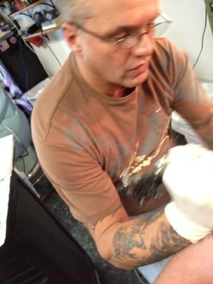 Owner/Artist Ron doing some work around an existing tattoo