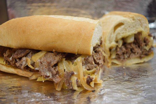 The Best Philly Steak with sizzling steak, melted cheese, and grilled onions.