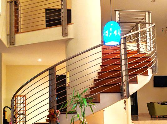 Industrial stainless steel cantilever radius staircase in a beautiful upscale residential home.