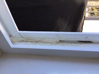 poorly applied caulking to hide the broken window frame