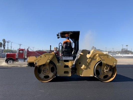 Skilled rollermen finishing the asphalt installation.