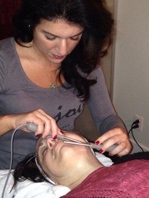 Julia giving a Microcurrent Facial.